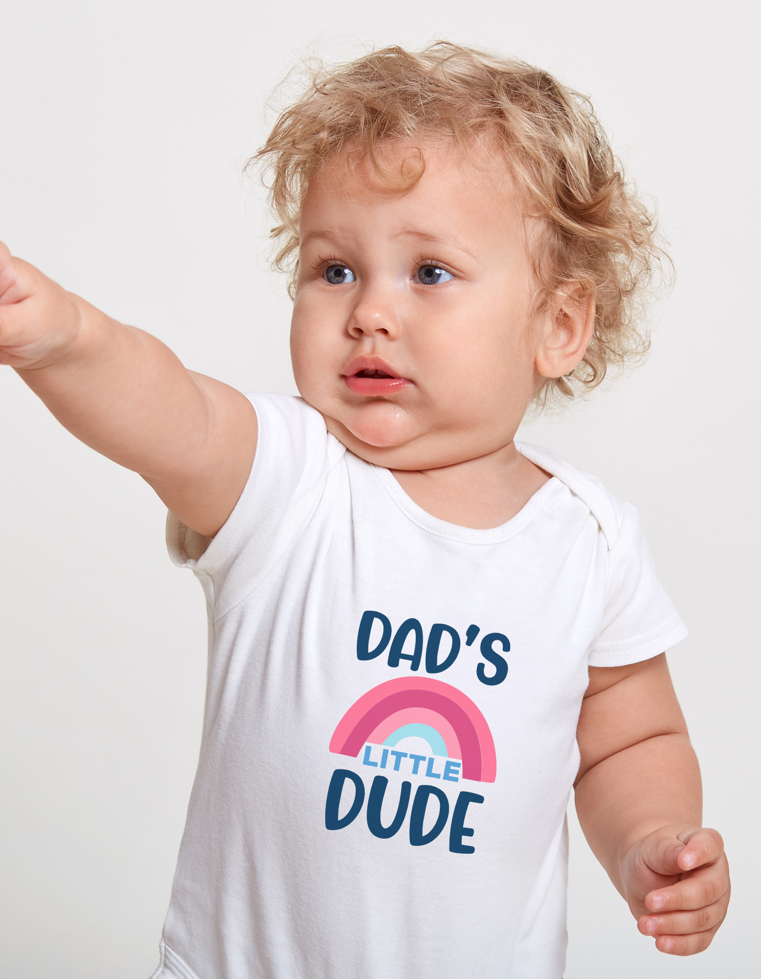 Child wearing a white t-shirt with 'Dad's Little Dude' text and rainbow design on a plain background