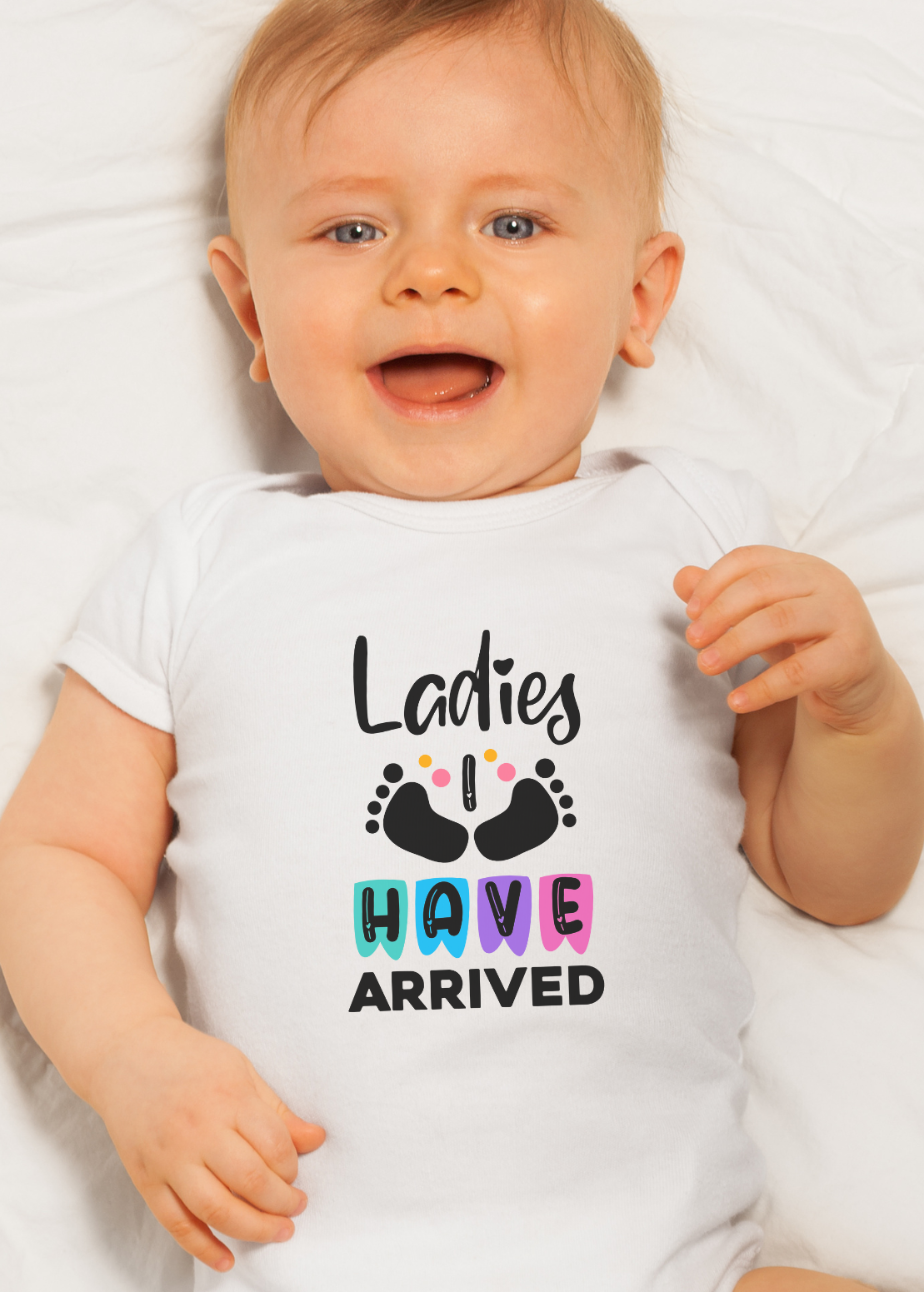 Baby wearing a white onesie with colorful text "Ladies I have arrived" on a white background
