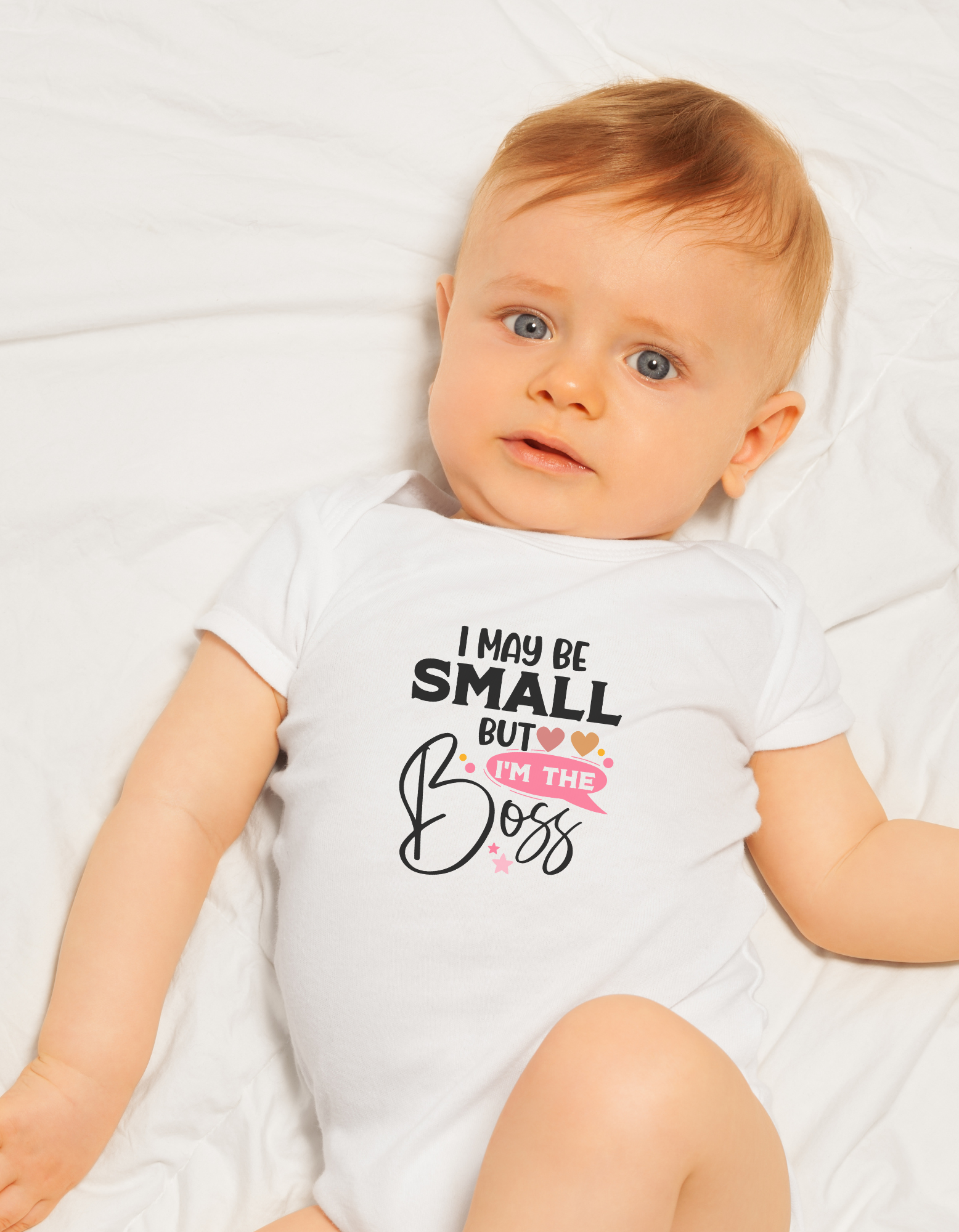 Baby wearing a white onesie with text - I may be small but I'm the boss