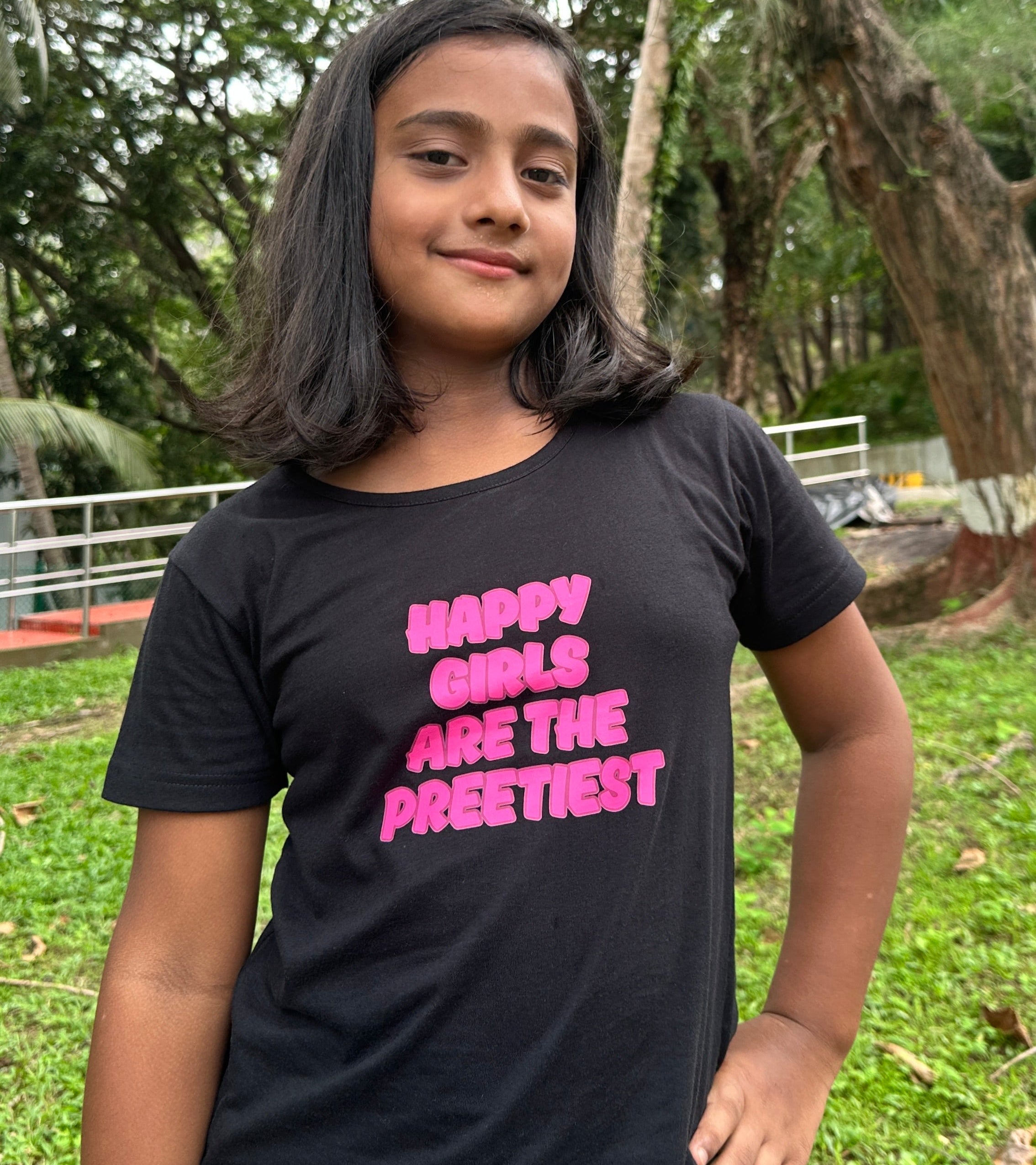 Young girl wearing a black t-shirt with pink text in an outdoor setting Mummas's Cub
