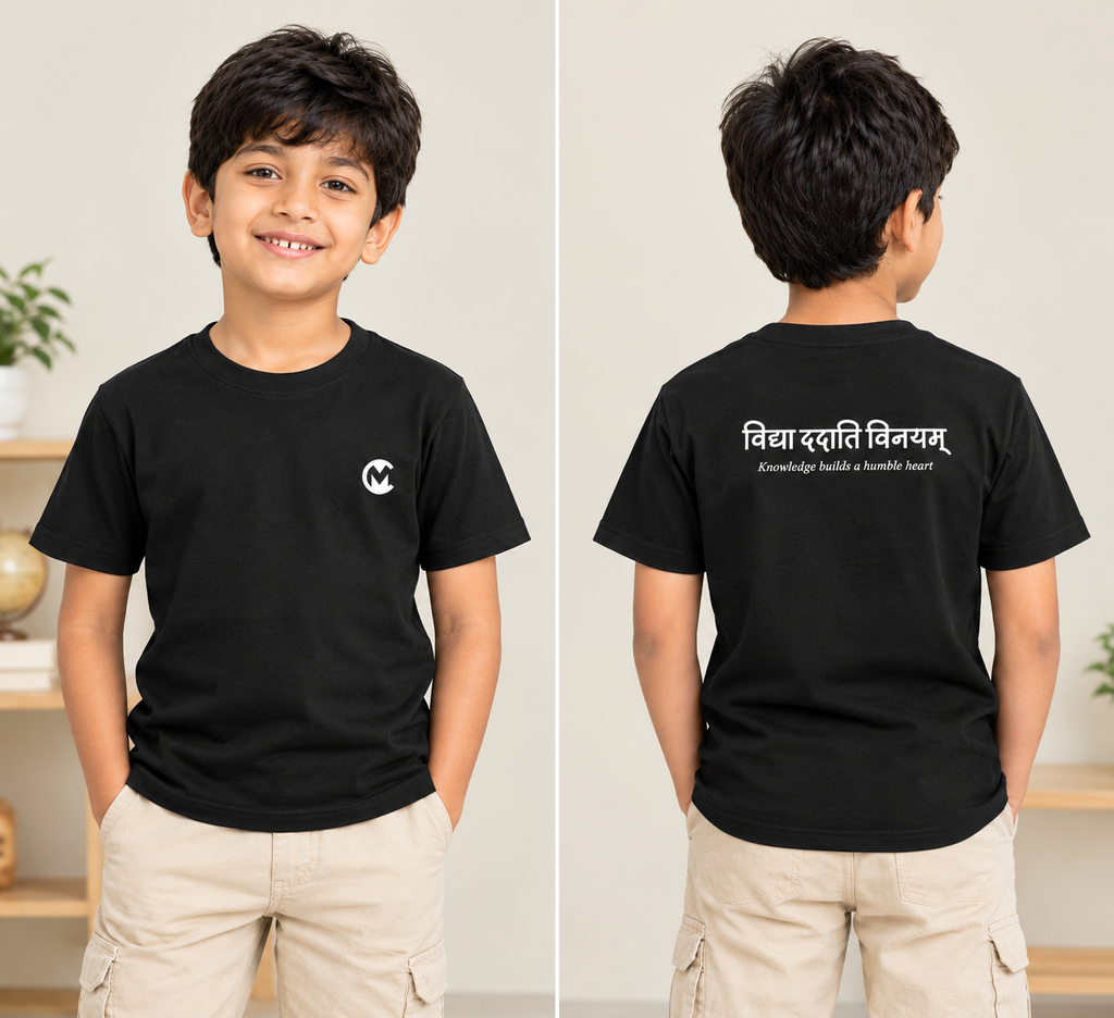 A young boy modeling a black short-sleeve t-shirt in a split front and back view. The front features a small white circular logo on the left chest, and the back features white text in Devanagari script reading 'विद्या दैत्य विनयम्' with 'Knowledge is the ultimate power' underneath.
