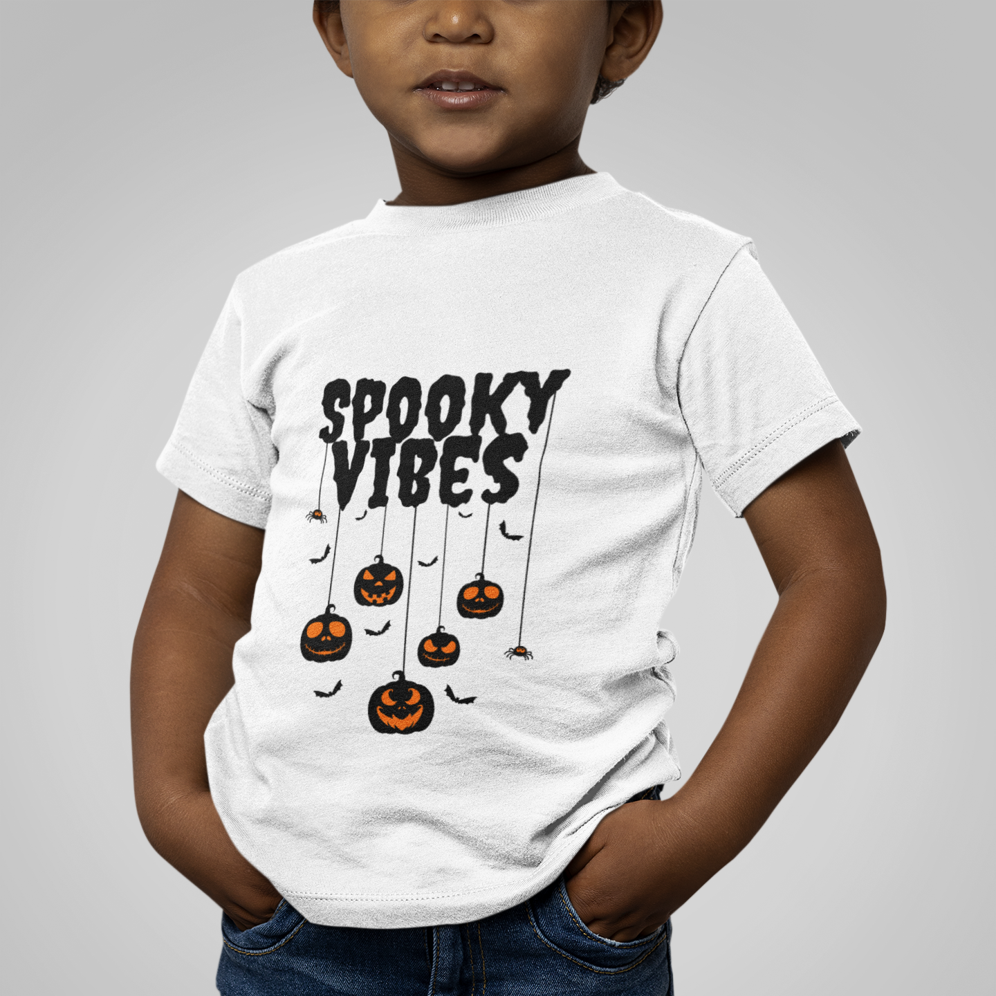 Kids unisex cotton Halloween T-shirt with small pumpkins hanging like spiders and text “Spooky Vibes”