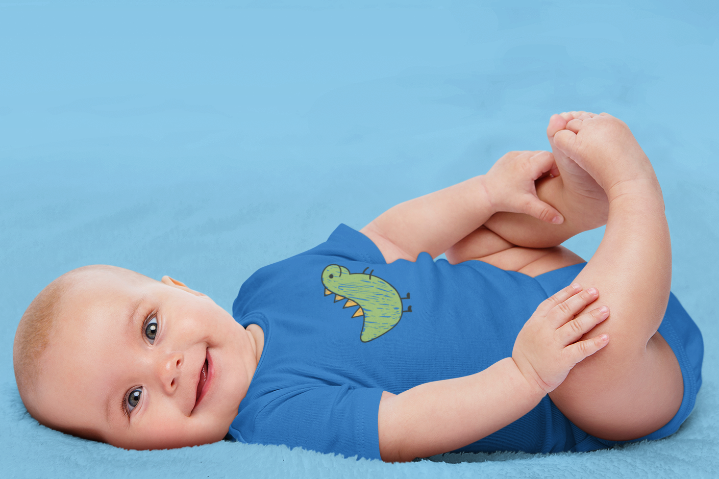 Baby wearing scribbled dinosaur print cotton onesie by Mumma’s Cub
