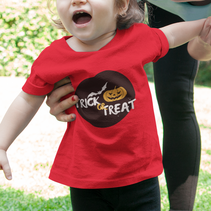 Woman and child outdoors with child wearing a red 'Trick or Treat' shirt