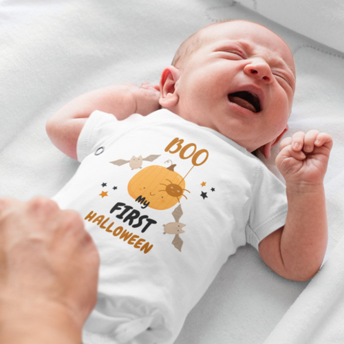 "Baby wearing Halloween onesie with pumpkin print and Boo text"