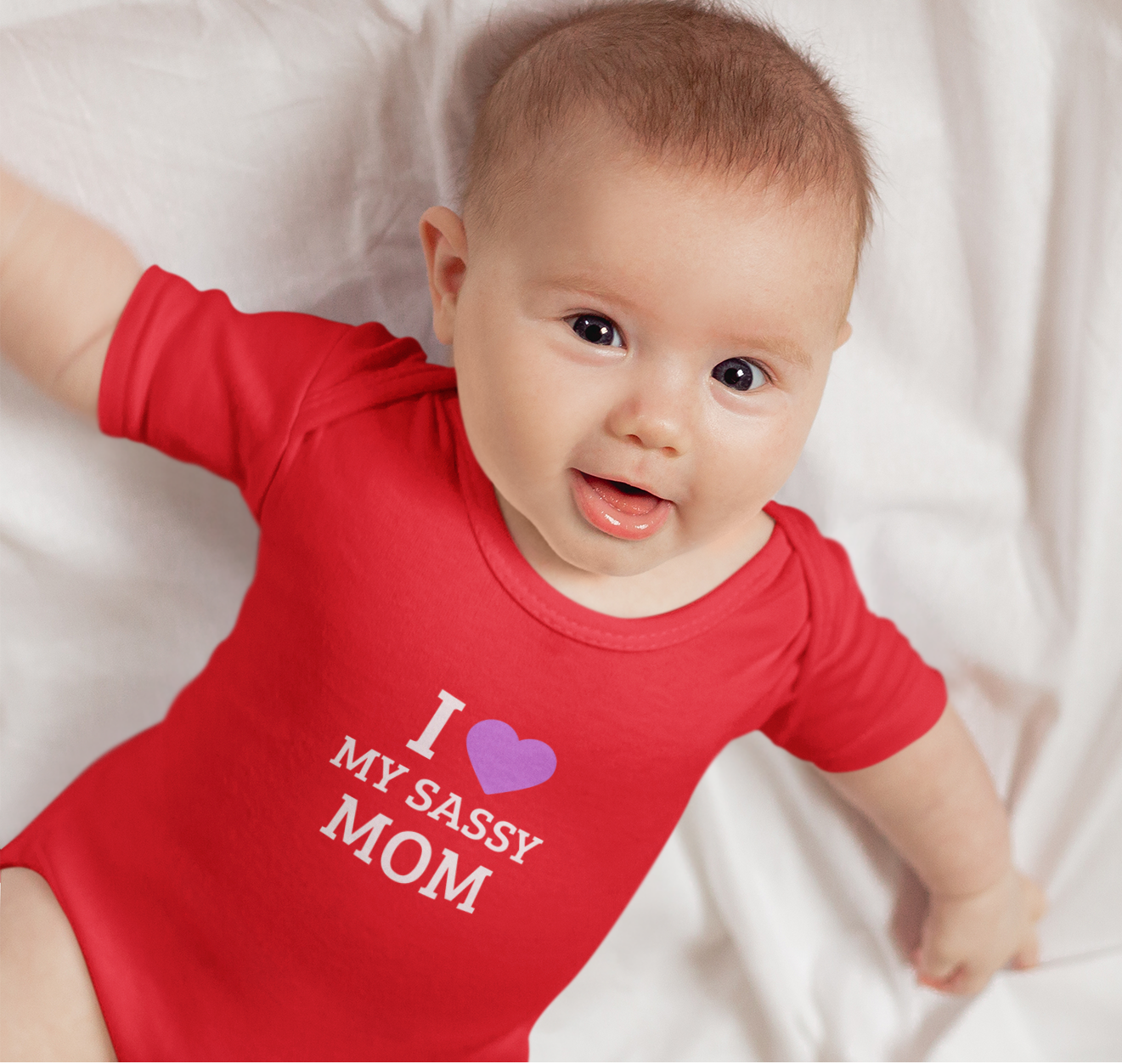 Baby wearing cotton onesie with “I Love My Sassy Mom” print by Mumma’s Cub