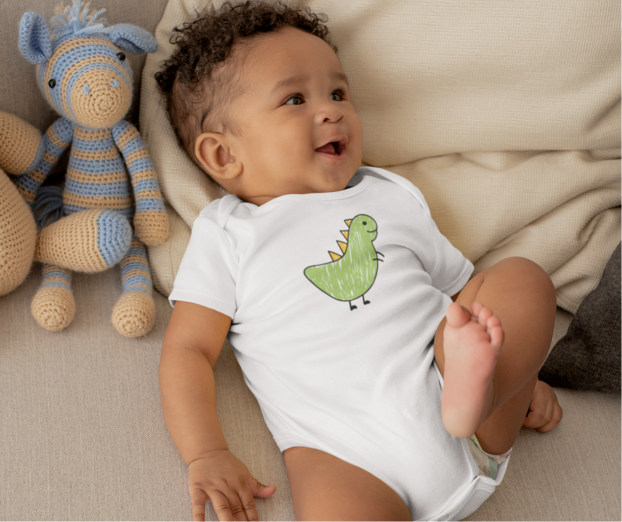 Baby wearing scribbled dinosaur print cotton onesie by Mumma’s Cub